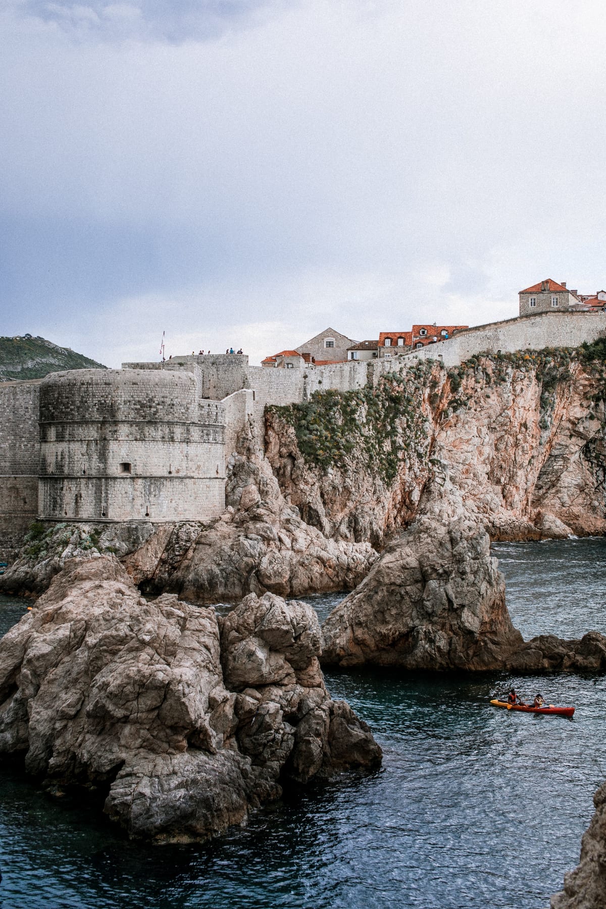 A stone fortress on a rocky coastal ridge above the Adriatic Sea.